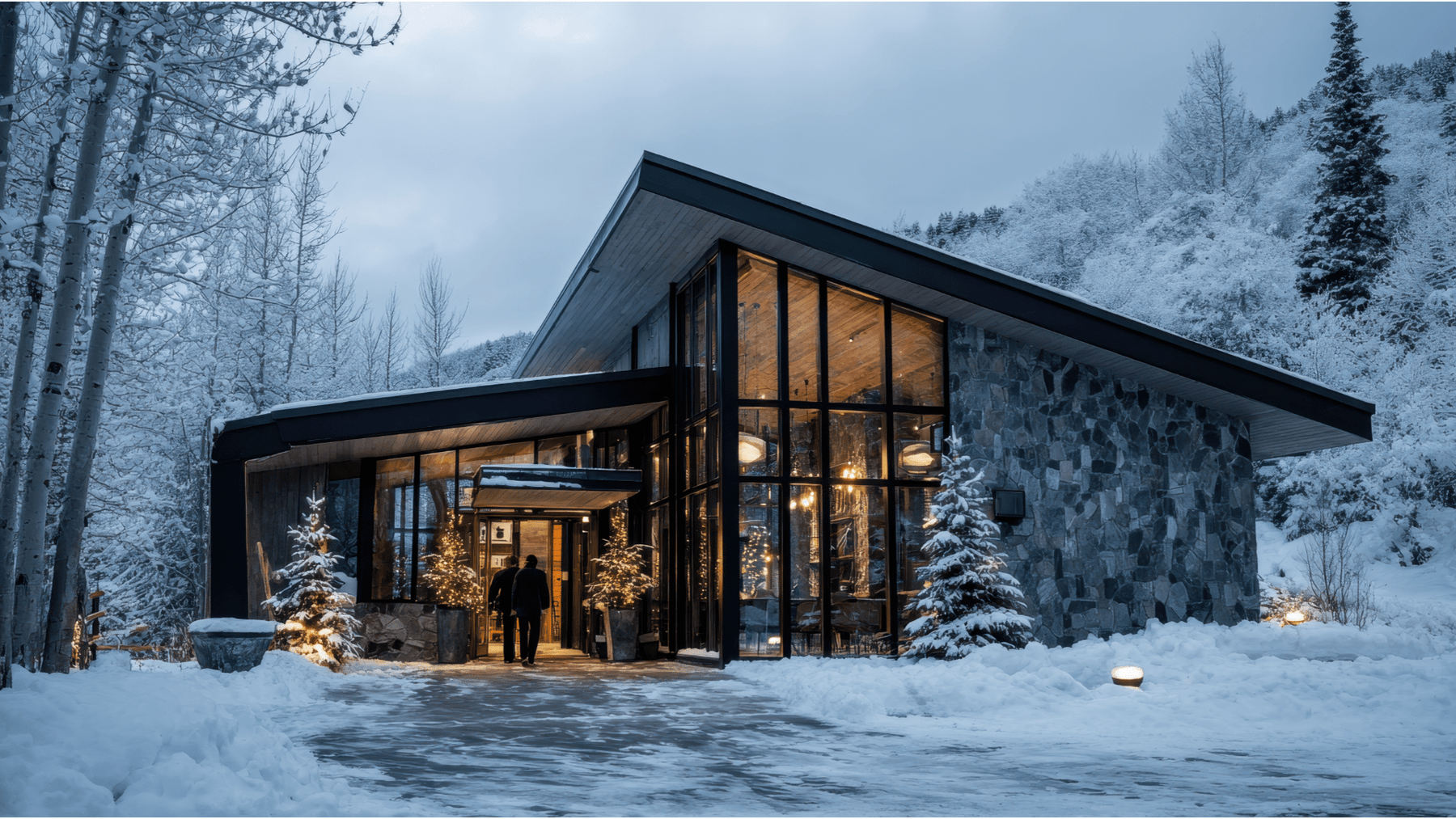 Modern winter cabin with warm lights and a clear snowy entry path, illustrating holiday hosting tips for outdoor spaces.